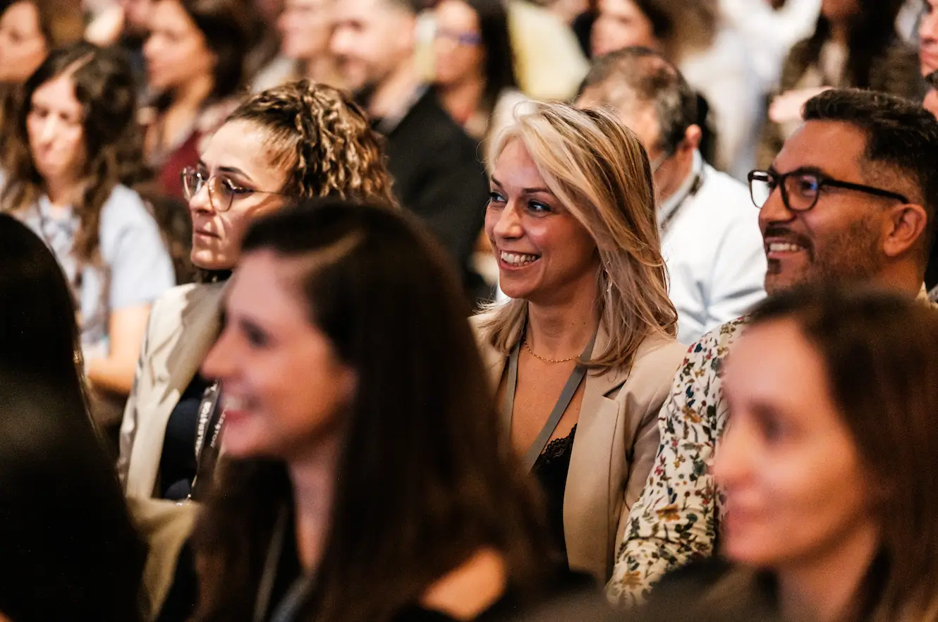 Participantes sorridentes na plateia do Master and Scale